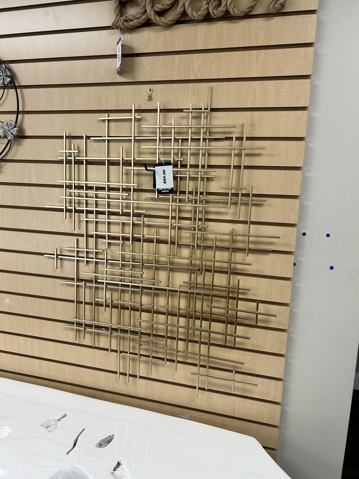 Geometric metal wall art displayed on slatwall in the consignment showroom